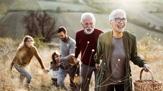 Eine Familie hat Spaß und geht über eine herbstliche Wiese